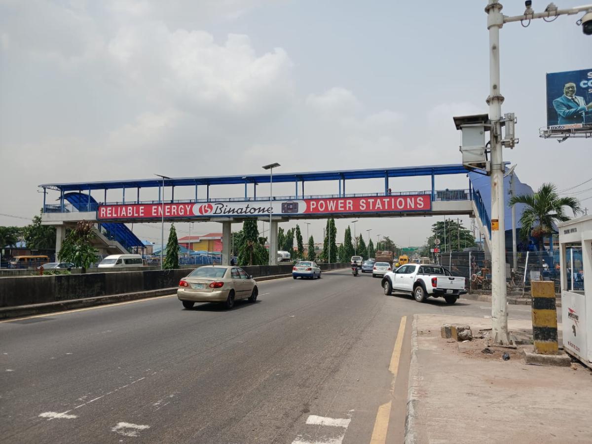 High-impact pedestrian bridge panel at Alapere/Estate Bus Stop, Lagos-Ibadan Expressway. Captures 10K+ daily pedestrians + massive vehicular traffic. Premium Ketu/Alapere corridor with decision-makers + corporate audience. 8x2ft LASAA-approved panel, eye-